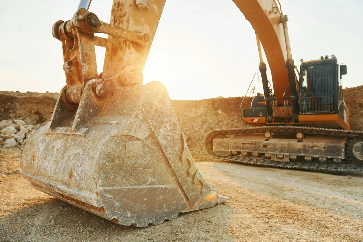 PlantFix UK: a tracked excavator on a work site at sunset, the kind of plant machinery it services and repairs.